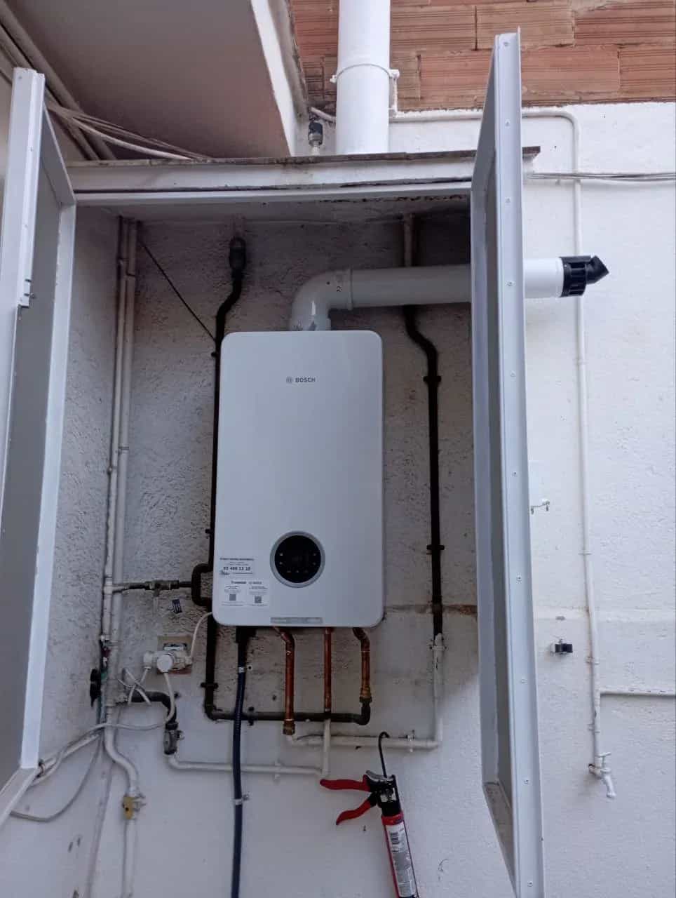 Caldera instalada dentro de un armario con conexiones de gas y agua – trabajo real de Climate Control Solutions en Barcelona