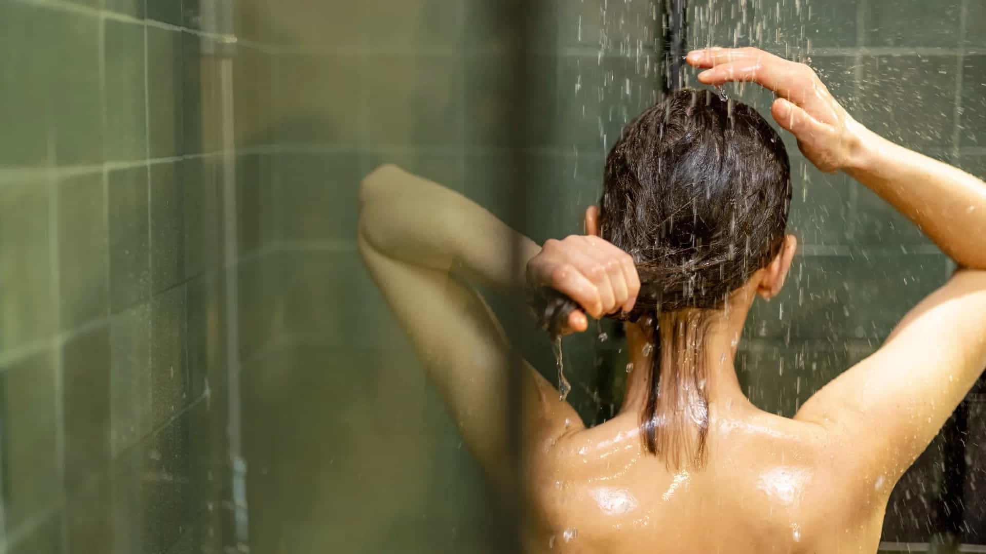 Mujer bajo la ducha con agua caliente