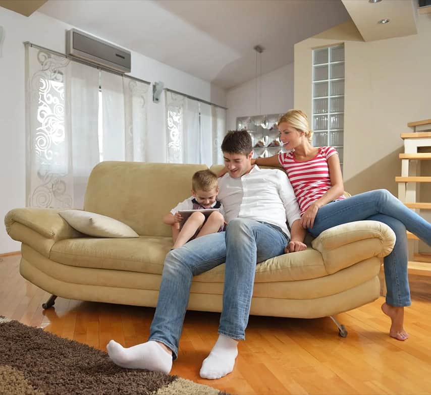 Familia en el salón de casa con el aire acondicionado encendido
