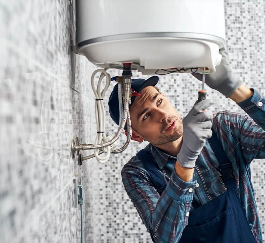 Instalador fijando un termo eléctrico en una pared alicatada