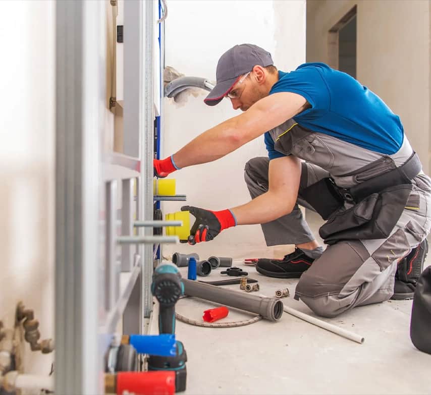 Instalador trabajando en las tuberías de una vivienda