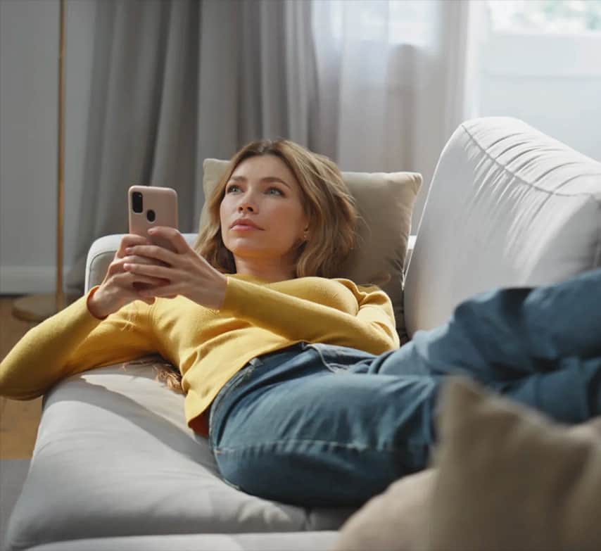 Mujer relajada en el sofá con una temperatura agradable en casa