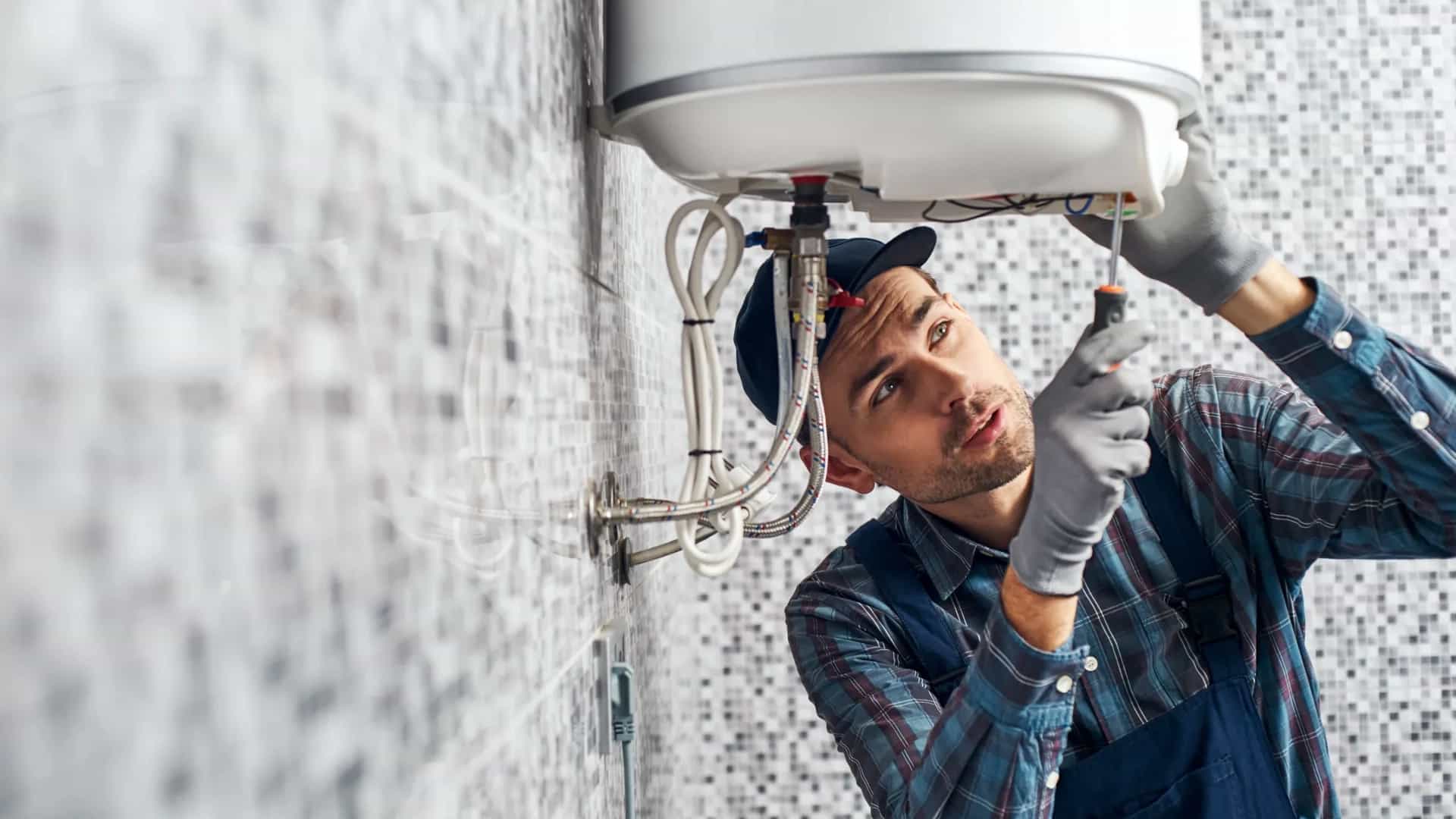 Técnico reparando la conexión de un termo eléctrico