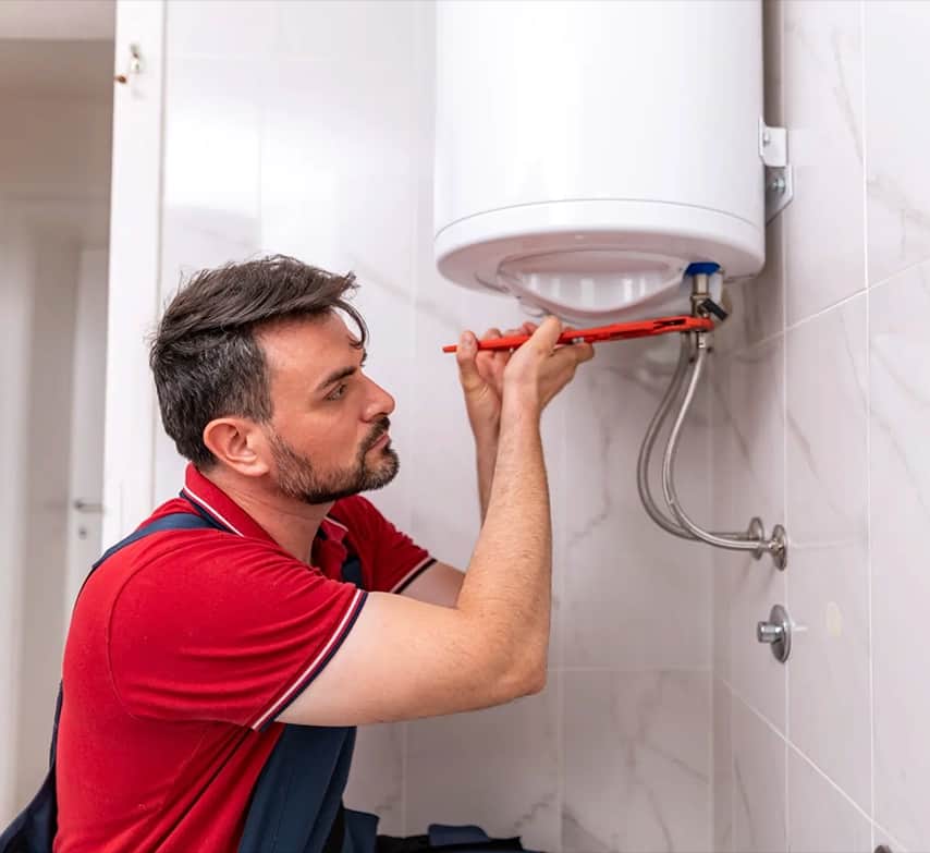 Técnico cambiando un termo eléctrico en un baño