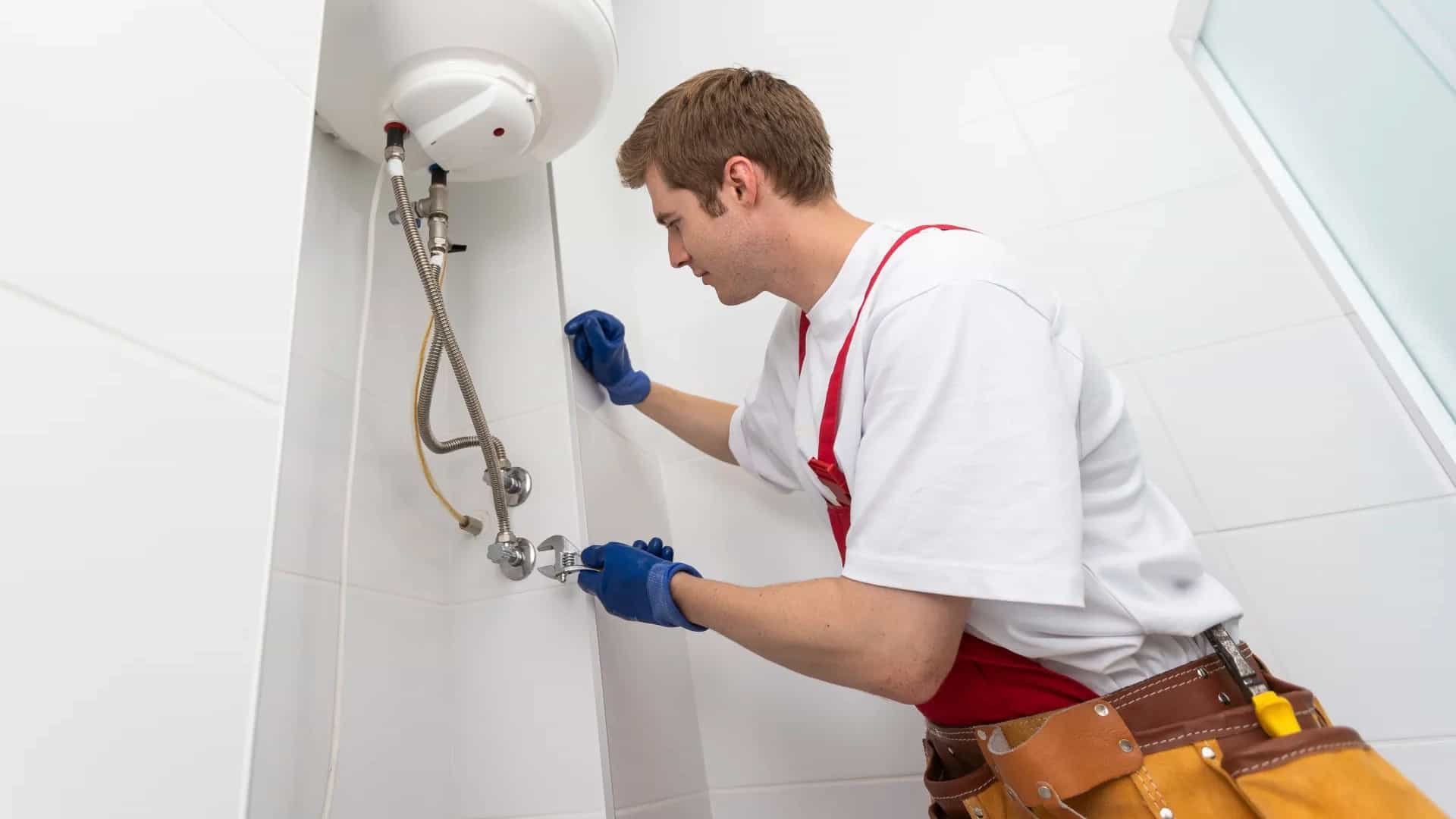 Técnico instalando un termo eléctrico en un baño