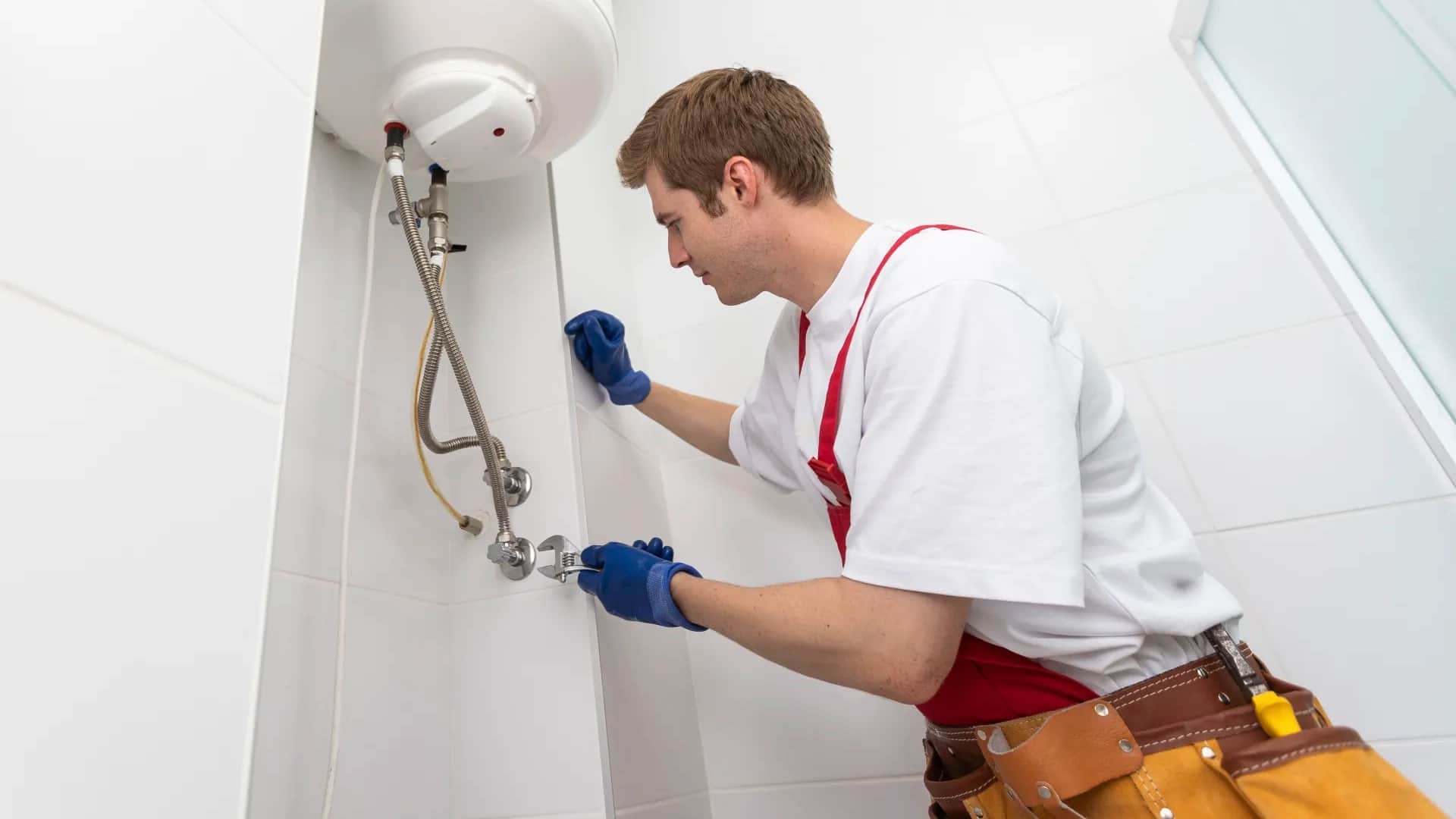 Técnico instalando un termo eléctrico en un baño