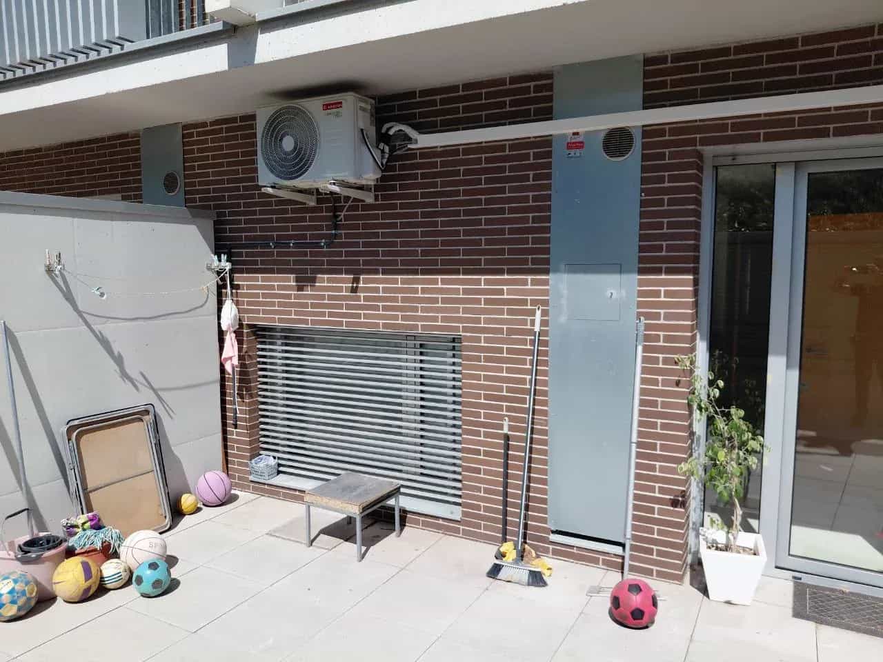 Unidad exterior de aire acondicionado instalada en la fachada de un patio interior de Barcelona