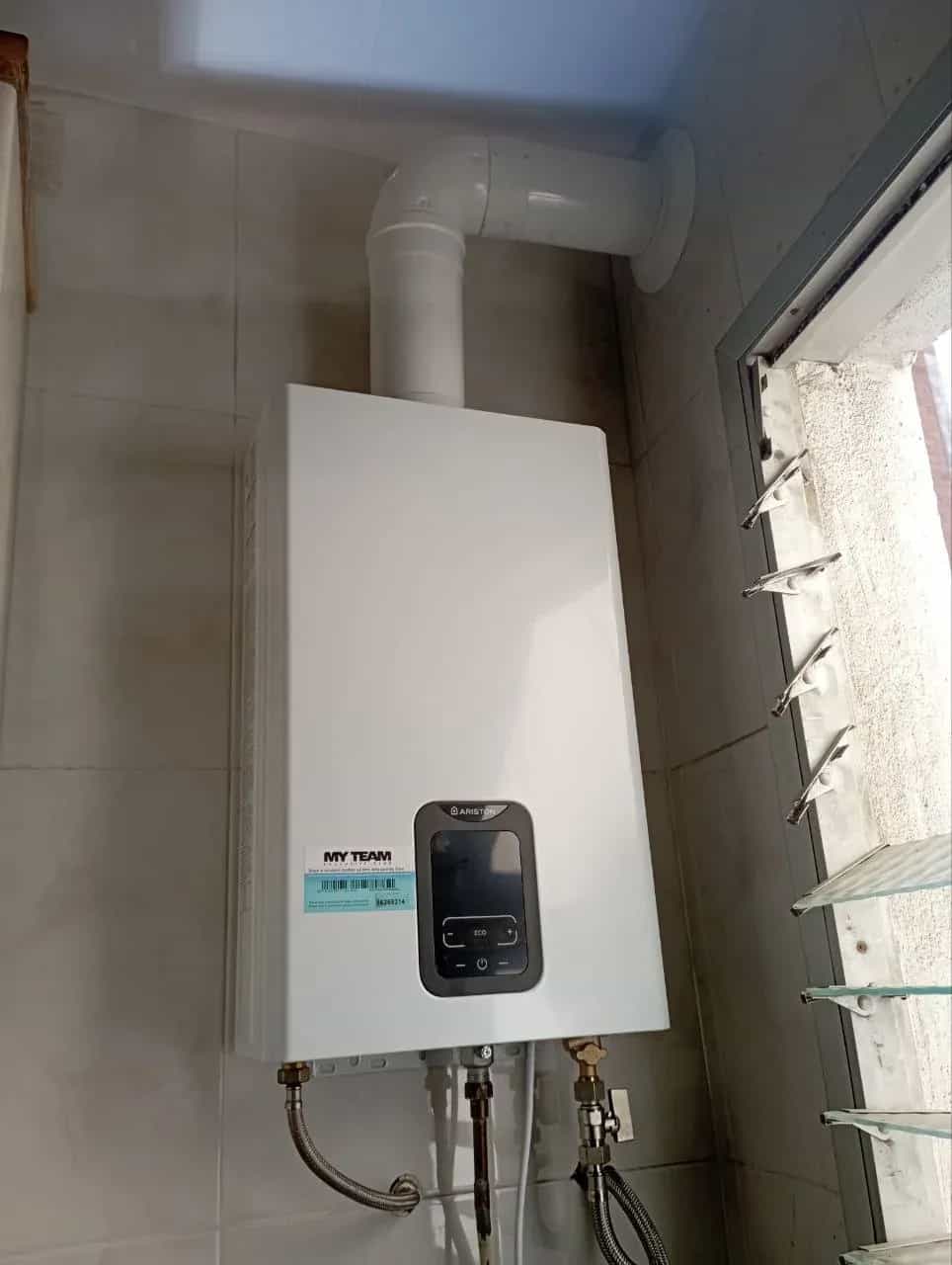Calentador de gas estanco con pantalla digital instalado en una galería de Barcelona